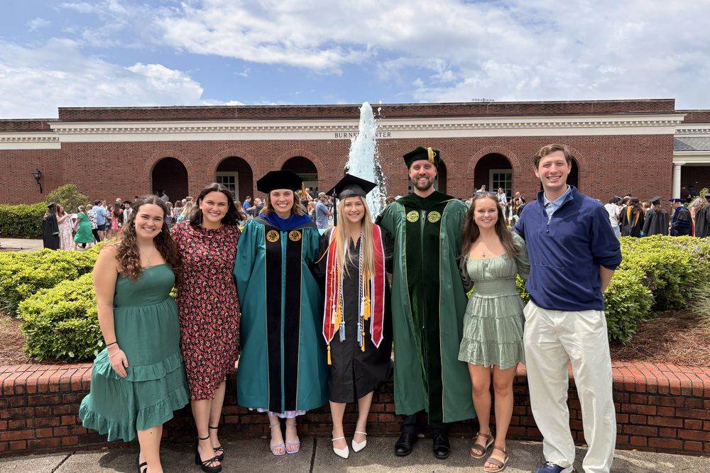 Lab members and graduates outside the Burney Center at UNCW commencement