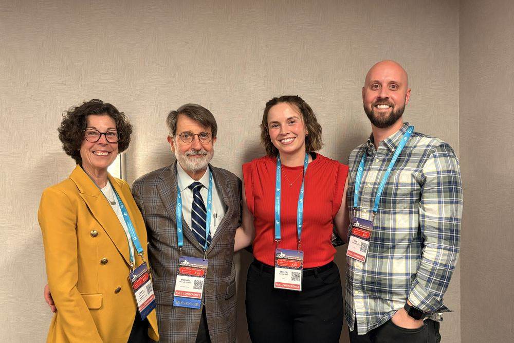 Four conference attendees with badges at the Texas Association for Behavior Analysis annual conference